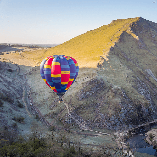 Multicoloured Balloon flying over mountains